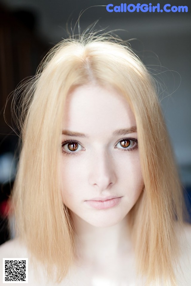 A woman with long blonde hair is posing for a picture.