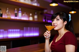 A woman in a red dress posing in front of a bar.