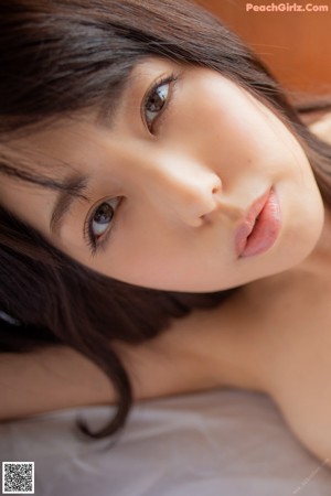 A naked woman laying on a bed with her back to the camera.