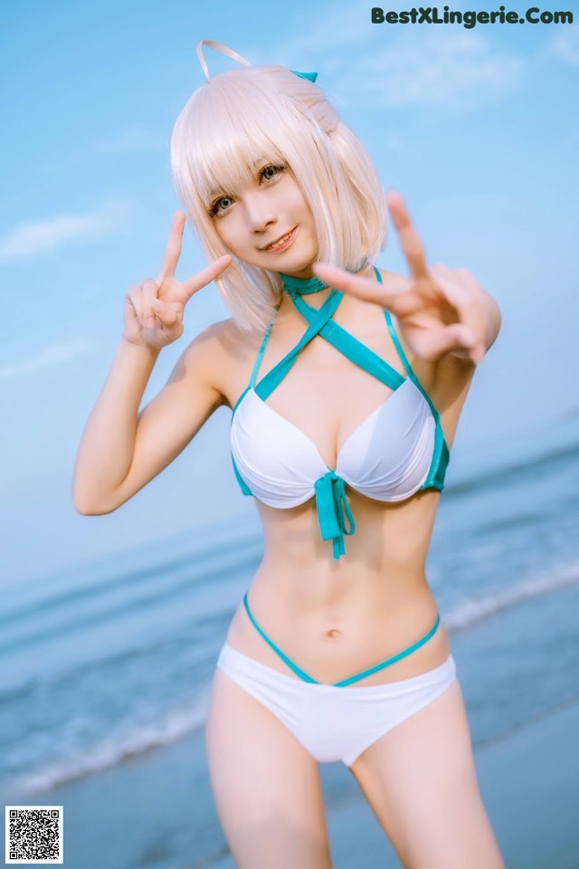 A woman in a bikini posing on the beach.