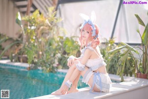 A woman in a bunny costume is floating in a pool.