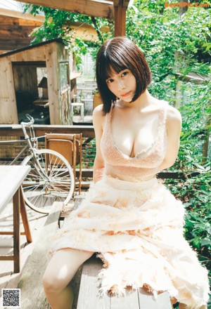 A woman in a yellow lingerie sitting on the floor.