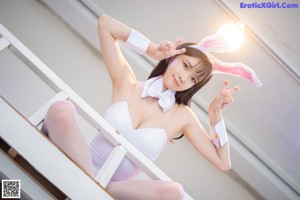 A woman in bunny ears sitting on a couch.