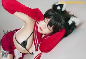 A woman in a red skirt and white socks is bending over.