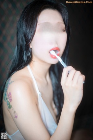 A woman brushing her teeth with a toothbrush.