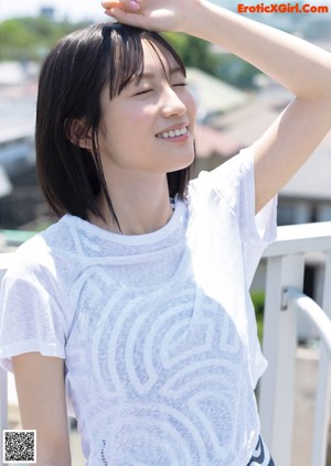 A woman in a white shirt and black skirt posing for a picture.