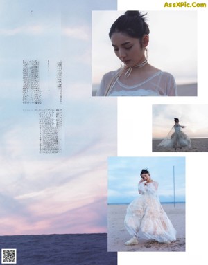 A woman in a white dress standing on a rock by the ocean.