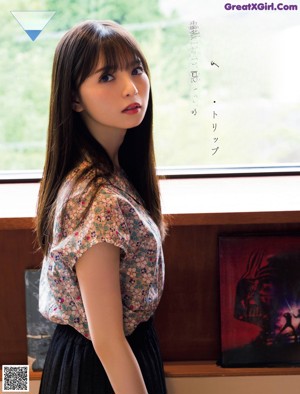 A woman standing on a wooden deck next to a fence.