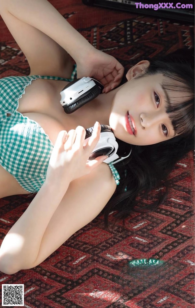A woman laying on the floor with headphones on.