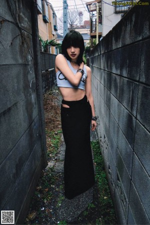 A woman standing in a hallway with her hands on her hips.