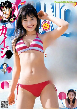 A woman in a blue bikini laying on the ground.