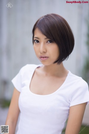 A woman in a white lingerie standing in a kitchen.