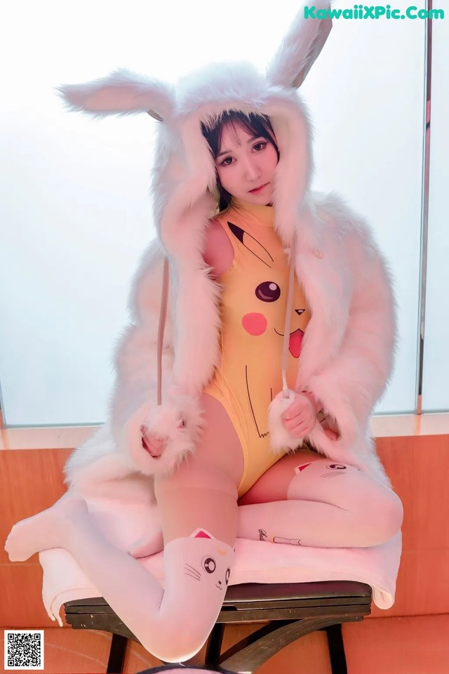 A woman in a bunny costume sitting on a chair.